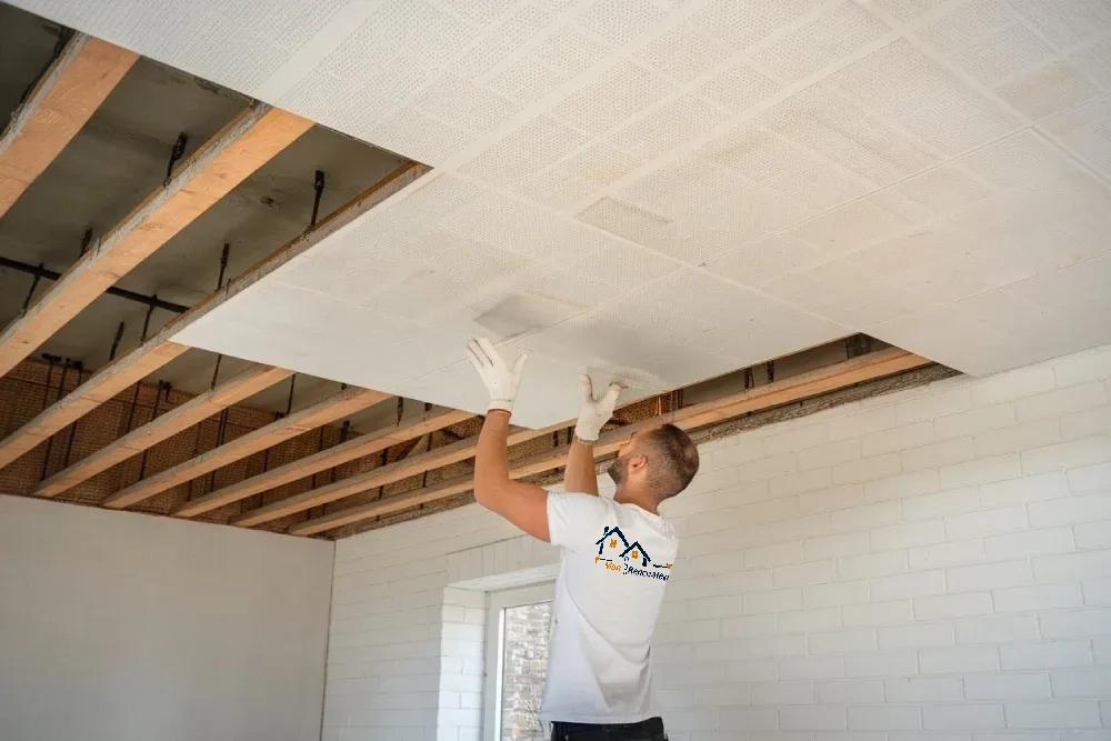 Artisan qualifié de Mon Rénovateur posant un faux plafond dans un appartement parisien